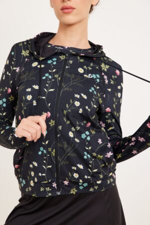 רוכבת אופנה נוחה ללבישה עם עיצובים פרחים צבעוניים על מעיל חורף שחור.