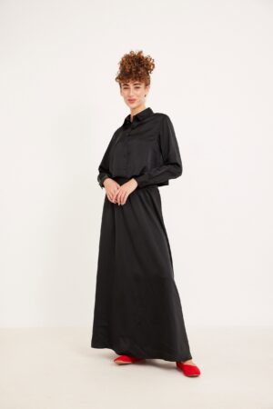 חולצת מכופתרת שחורה עם מכנסי גלישה ארוכים, לבוש אופנתי ושלם לנשים.